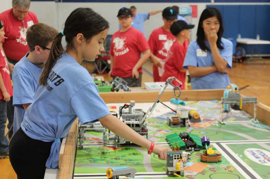 Girl competing with legos. 