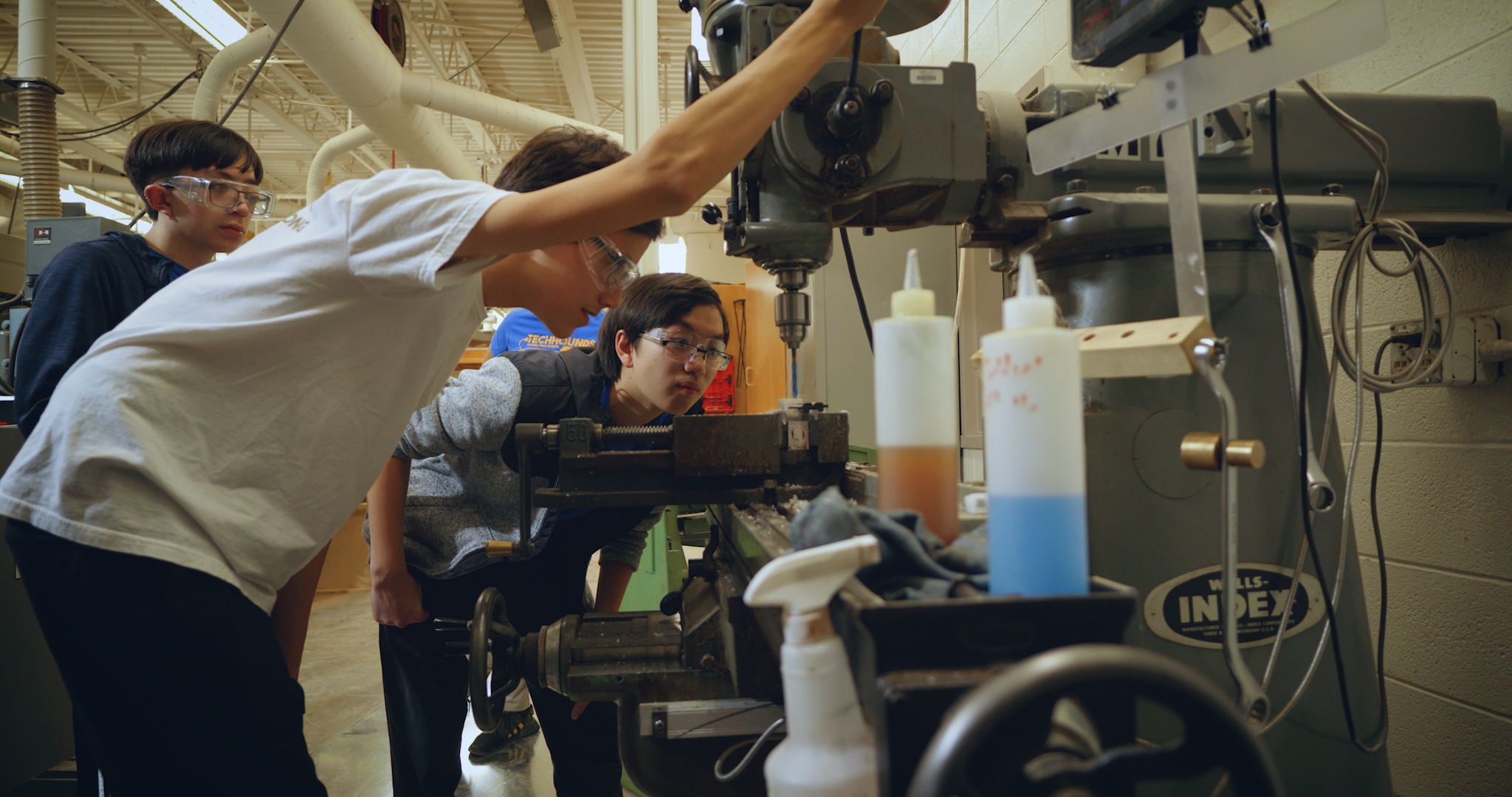 Two participants using a drill press.