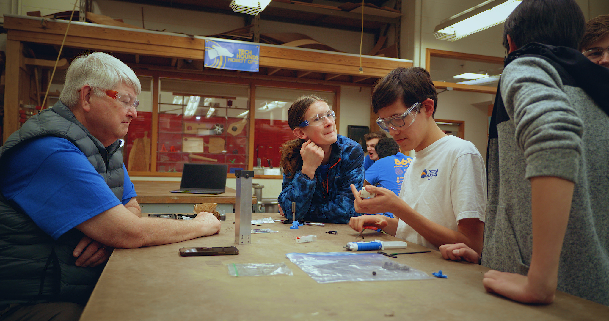 Boy and Girl with safety glasses on looking at parts