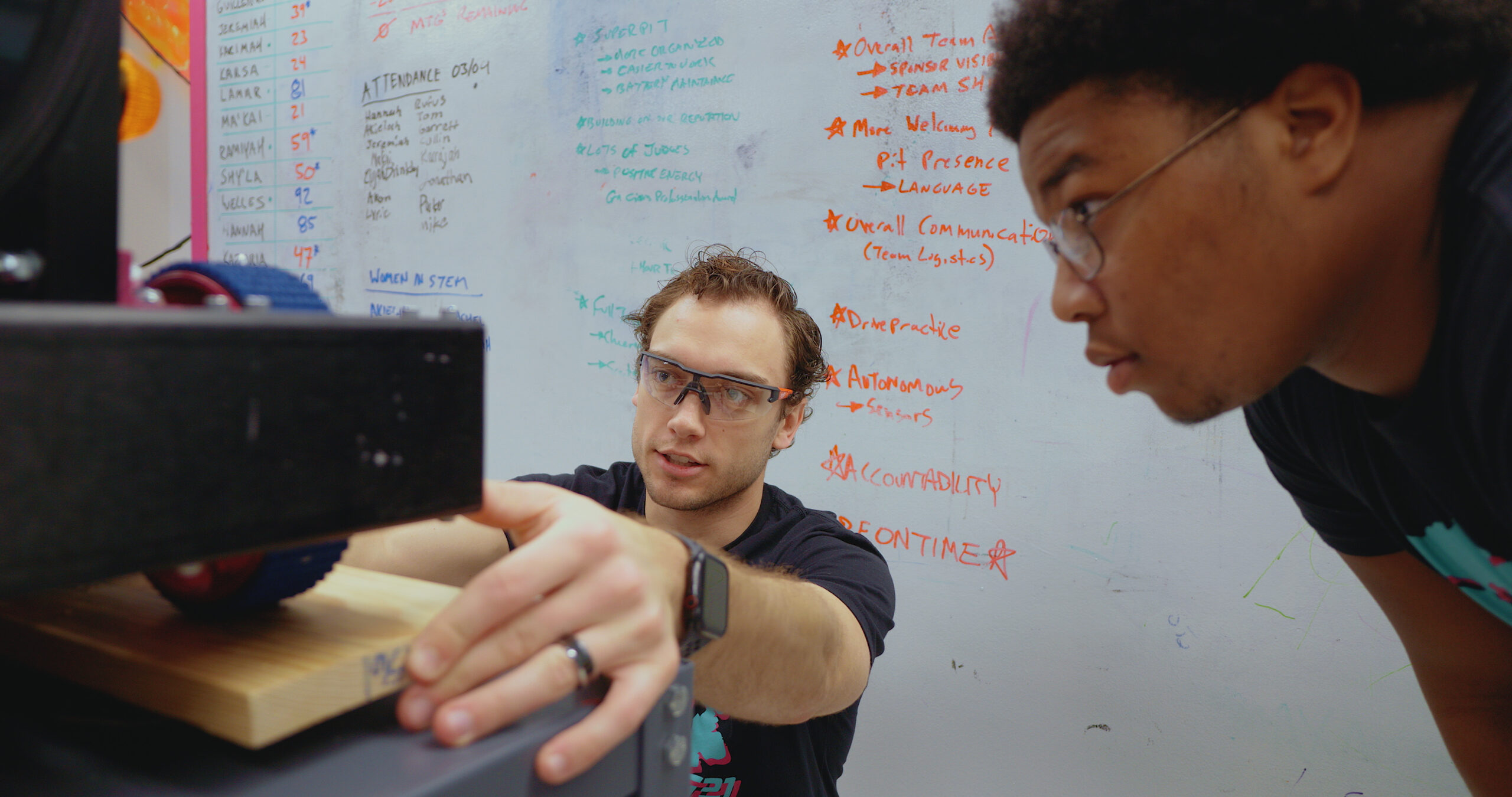 Two students focusing on the robot
